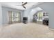 Spacious bonus room with built-in desks and shelves, a ceiling fan, and plenty of natural light at 7409 Tarland Ln, Charlotte, NC 28269