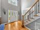 Bright foyer with hardwood floors, staircase with decorative iron railing, and a leaded glass front door at 7409 Tarland Ln, Charlotte, NC 28269