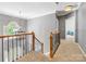 Upstairs hallway with wrought iron railing overlooks foyer and leads to bedrooms at 7409 Tarland Ln, Charlotte, NC 28269