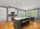 Bright kitchen with hardwood floors, an island with seating, and a view to the dining area at 7409 Tarland Ln, Charlotte, NC 28269