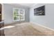 Inviting living room featuring neutral carpeting and trim, complemented by abundant natural light at 7409 Tarland Ln, Charlotte, NC 28269