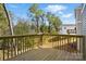 View of the back deck showing the wood flooring and railing overlooking the backyard and trees at 76 Snyder Ne Ct, Concord, NC 28025