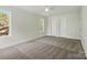 Spacious bedroom with neutral carpet, three windows, and two closet doors at 76 Snyder Ne Ct, Concord, NC 28025