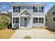 Charming two-story home with a light blue exterior, black shutters, and inviting front porch and well manicured lawn at 76 Snyder Ne Ct, Concord, NC 28025