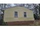 This yellow home features a brick foundation, and two windows on the side at 828 Williams St, Gastonia, NC 28052