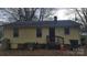 Side exterior view of home featuring yellow siding, AC, and back door entrance at 828 Williams St, Gastonia, NC 28052