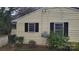 This yellow home features black shutters, and lush landscaping at 828 Williams St, Gastonia, NC 28052
