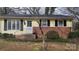 Front exterior of home featuring yellow siding, brick foundation, and manicured landscaping at 828 Williams St, Gastonia, NC 28052
