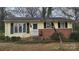 Charming yellow home features a brick foundation, black shutters, and a landscaped yard at 828 Williams St, Gastonia, NC 28052