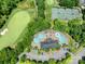 Stunning aerial view of the community pool, golf course, and tennis courts amidst lush greenery at 8710 Chewton Glen Dr, Waxhaw, NC 28173