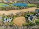 Expansive aerial view showcasing the neighborhood's elegant homes, golf course, and serene lake at 8710 Chewton Glen Dr, Waxhaw, NC 28173