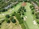 Aerial view of a green, manicured golf course with a pond, sand traps, and multi-million dollar homes at 8710 Chewton Glen Dr, Waxhaw, NC 28173