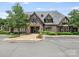 Elegant clubhouse featuring stone and brick architecture, a paved entrance, and landscaped grounds at 8710 Chewton Glen Dr, Waxhaw, NC 28173