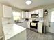 Well-lit kitchen featuring white cabinets, stainless steel appliances, and a sleek marble countertop at 903 Lakeview St, Kannapolis, NC 28083