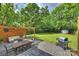 Landscaped backyard featuring a stone patio with comfortable seating and outdoor dining area at 908 Academy St, Charlotte, NC 28205