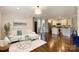 Bright living room with hardwood floors, open to the kitchen, and staircase at 908 Academy St, Charlotte, NC 28205