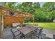 Relaxing patio area featuring a wooden pergola, outdoor furniture, and green lawn at 908 Academy St, Charlotte, NC 28205