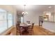 Bright dining room with chandelier, hardwood floors, and backyard views at 9101 Oak Bluff Ct, Marvin, NC 28173