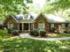 Traditional brick home with arched windows, manicured shrubs, and a walkway leading to a covered front entrance at 9101 Oak Bluff Ct, Marvin, NC 28173