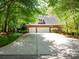 Spacious two-car garage and a large driveway are surrounded by lush trees, offering ample parking and privacy at 9101 Oak Bluff Ct, Marvin, NC 28173