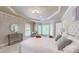 Light-filled main bedroom features a tray ceiling and multiple windows at 9101 Oak Bluff Ct, Marvin, NC 28173