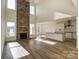Open concept living room with a floor-to-ceiling stone fireplace and modern kitchen at Tbd Boomer Ct # 3, Statesville, NC 28677