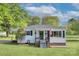 Charming home with white siding, black shutters, and well-maintained front lawn under a partly cloudy sky at 103 Moore Ave, Mount Holly, NC 28120