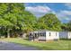 Inviting home with a cozy front porch and manicured lawn, surrounded by mature, leafy trees at 103 Moore Ave, Mount Holly, NC 28120