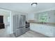 Well-lit kitchen featuring stainless steel appliances, white cabinets, and luxury vinyl plank flooring at 103 Moore Ave, Mount Holly, NC 28120