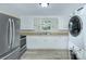 Modern laundry room equipped with stainless steel appliances and white cabinetry for ample storage at 103 Moore Ave, Mount Holly, NC 28120