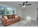 Inviting living room with natural light, a brown leather sofa, and modern ceiling fan at 103 Moore Ave, Mount Holly, NC 28120