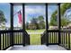 View from the porch steps showcases black wooden rails and a grassy area with scattered trees at 103 Moore Ave, Mount Holly, NC 28120