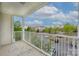 Condo balcony with white railing, overlooking a parking lot and landscaped grounds with trees at 11544 Costigan Ln # 8306, Charlotte, NC 28277