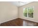 Cozy bedroom features hardwood floors and a window offering a neighborhood view at 11544 Costigan Ln # 8306, Charlotte, NC 28277