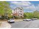 Three-story condo building with brick and siding, balconies, and parking lot on a partly cloudy day at 11544 Costigan Ln # 8306, Charlotte, NC 28277