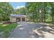 A detached two-car garage with a metal roof and concrete driveway surrounded by lush trees at 119 Legacy Ln, Harmony, NC 28634