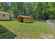 A backyard wooden storage shed surrounded by a chain link fence at 119 Legacy Ln, Harmony, NC 28634