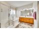 Well-lit bathroom featuring a glass-enclosed shower, separate tub, and double sink vanity with ample storage at 14818 Hawick Manor Ln, Pineville, NC 28134
