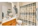 Bright bathroom with a single sink vanity and a shower-tub combo with a patterned curtain at 14818 Hawick Manor Ln, Pineville, NC 28134