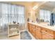 Well-lit bathroom featuring a double vanity and a large window at 14818 Hawick Manor Ln, Pineville, NC 28134