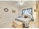 Comfortable bedroom with neutral carpet, light walls, and a charming window with blue curtains at 14818 Hawick Manor Ln, Pineville, NC 28134