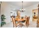 Elegant dining area with a round table, six chairs, chandelier, and view into the living room at 14818 Hawick Manor Ln, Pineville, NC 28134