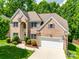 Traditional two-story brick home with manicured landscaping, attached garage, and a well-maintained lawn at 14818 Hawick Manor Ln, Pineville, NC 28134