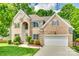 Charming two-story brick home with well-manicured lawn, lush landscaping, and a two car garage at 14818 Hawick Manor Ln, Pineville, NC 28134