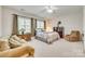 Large main bedroom featuring a ceiling fan, natural light, and a cozy sitting area, perfect for relaxation at 14818 Hawick Manor Ln, Pineville, NC 28134