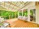 Outdoor patio with seating area, a partial glass roof, and lush greenery at 14818 Hawick Manor Ln, Pineville, NC 28134
