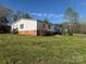 View of the home's vinyl siding, brick foundation, and surrounding yard at 196 Cindy Ln, Kings Mountain, NC 28086