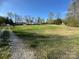 Spacious front yard with grass and mature trees with a home in the background under a clear blue sky at 196 Cindy Ln, Kings Mountain, NC 28086