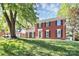 Traditional brick home featuring black shutters, a manicured lawn, and mature trees at 200 Port Royal Dr, Matthews, NC 28105