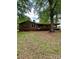 Single story home with a brick exterior and covered parking surrounded by mature trees in the front yard at 204 Long Creek Rd, Bessemer City, NC 28016